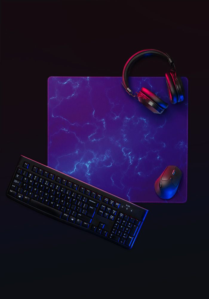 Desk mat with purple electric design, keyboard, mouse and headphones
